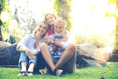 Portrait of smiling family sitting in park