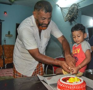 Grandfather cutting cake with grandson at home