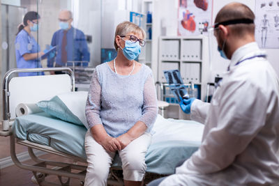 Portrait of doctor examining patient in hospital