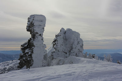 Snow covered landscape against sky