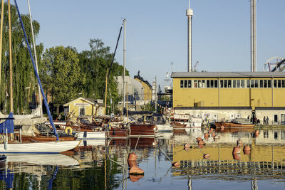 Boats moored at harbor against clear sky