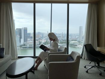 Woman sitting on table by window