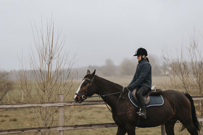 View of girl horseback riding