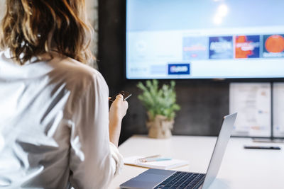 Businesswoman using projection screen in office