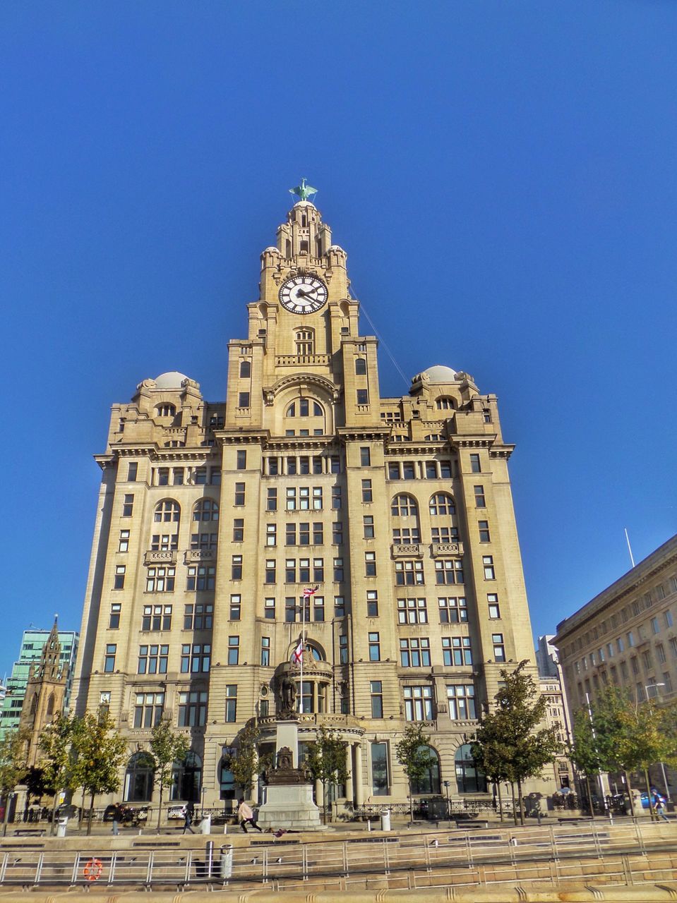 architecture, building exterior, built structure, city, clear sky, tall - high, street, low angle view, blue, city life, skyscraper, tower, outdoors, office building, growth, day, building story, modern, sky, development, spire, urban skyline, facade