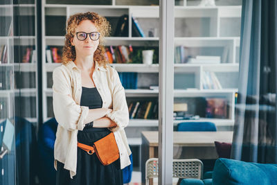 Portrait of young woman standing in library