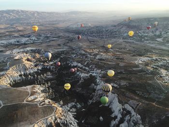 Hot air balloons over rocky landscape