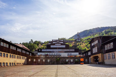 Buildings in town against cloudy sky