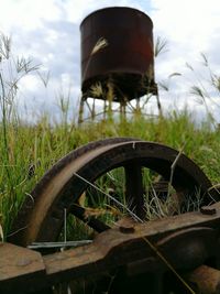 Close-up of rusty wheel on field