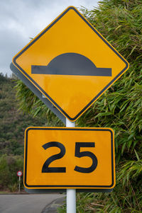 Close-up of road sign against sky