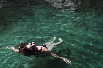 High angle view of young woman floating in water at night