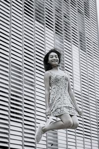 Portrait of smiling young woman against white wall