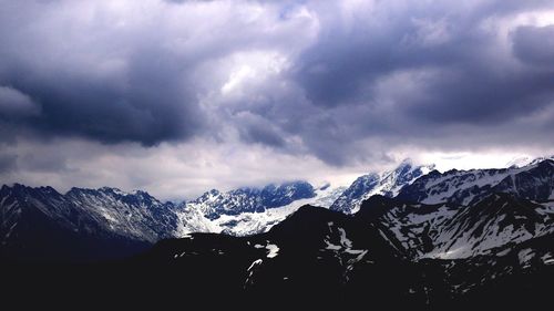 Scenic view of mountains against cloudy sky