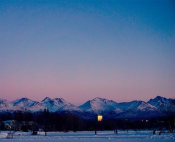 Scenic view of snowcapped mountains against clear blue sky during winter