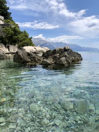 Rocks in sea against sky