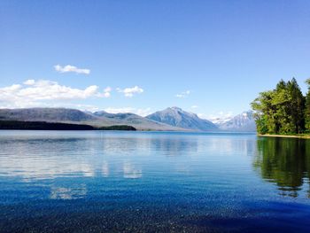 Scenic view of lake and mountains against blue sky