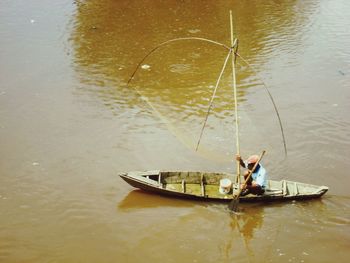 High angle view of mature man sitting in boat sailing on sea