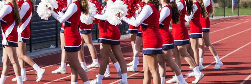 Midsection of cheerleaders on running track