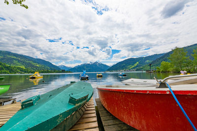 Boats moored in lake against sky