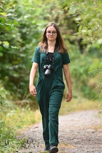 Portrait of young woman standing on road