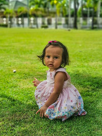 Cute girl sitting on field