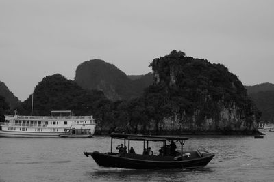 People on boat in river against clear sky