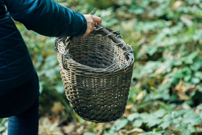 Midsection of man holding basket in field