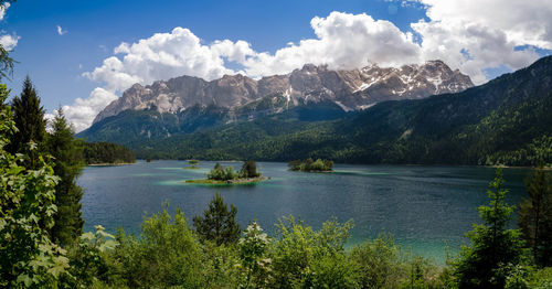 Scenic view of lake by trees against sky