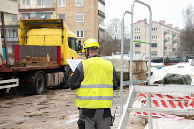 The construction manager looks at the drawing design while standing on the construction site