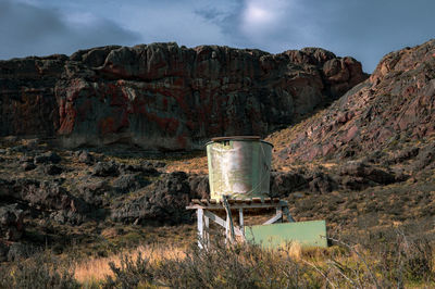 Built structure on rocky mountain against sky