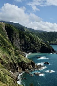 Scenic view of sea and mountains against sky