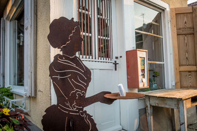 Reflection of man smoking cigarette on table by window