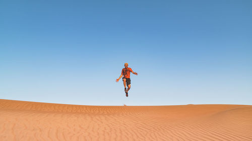 Man jumping against clear sky