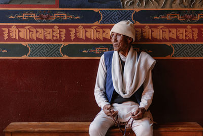 Full length of man sitting on wall