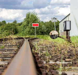 Railroad tracks by trees against sky