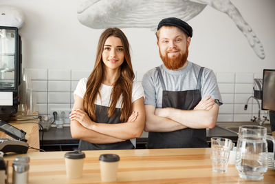 Portrait of smiling female friends working in cafe