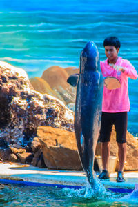 Boy standing by sea