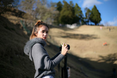 Portrait of young woman standing on land