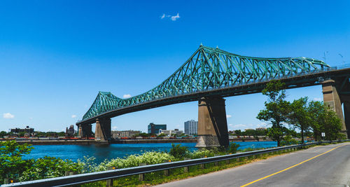 View of bridge over river against blue sky