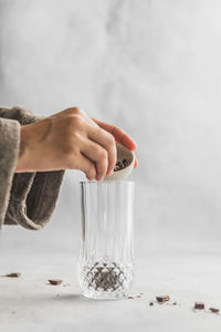 Close-up of hand holding glass on table