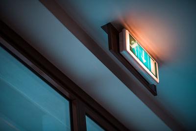 Low angle view of illuminated sign on wall