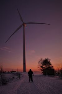 Woman standing on field against sky during winter