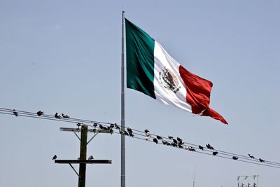 Low angle view of flags against clear sky
