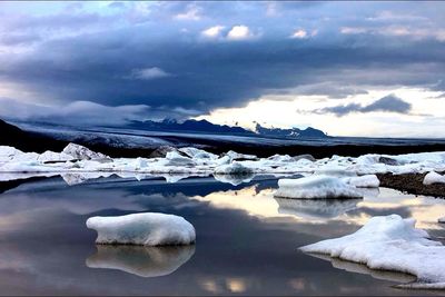 Scenic view of lake against cloudy sky