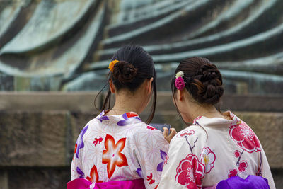 Rear view of women with umbrella