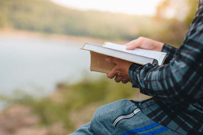 Midsection of man holding book