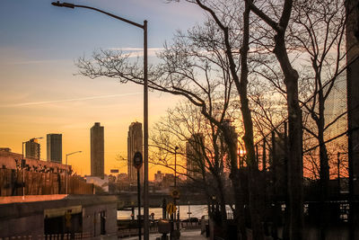 Silhouette trees and buildings against sky during sunset