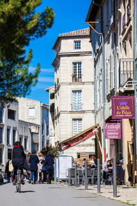 People on street against buildings in city