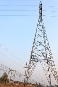 Low angle view of electricity pylon against clear sky