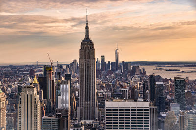 Modern buildings in city against sky during sunset